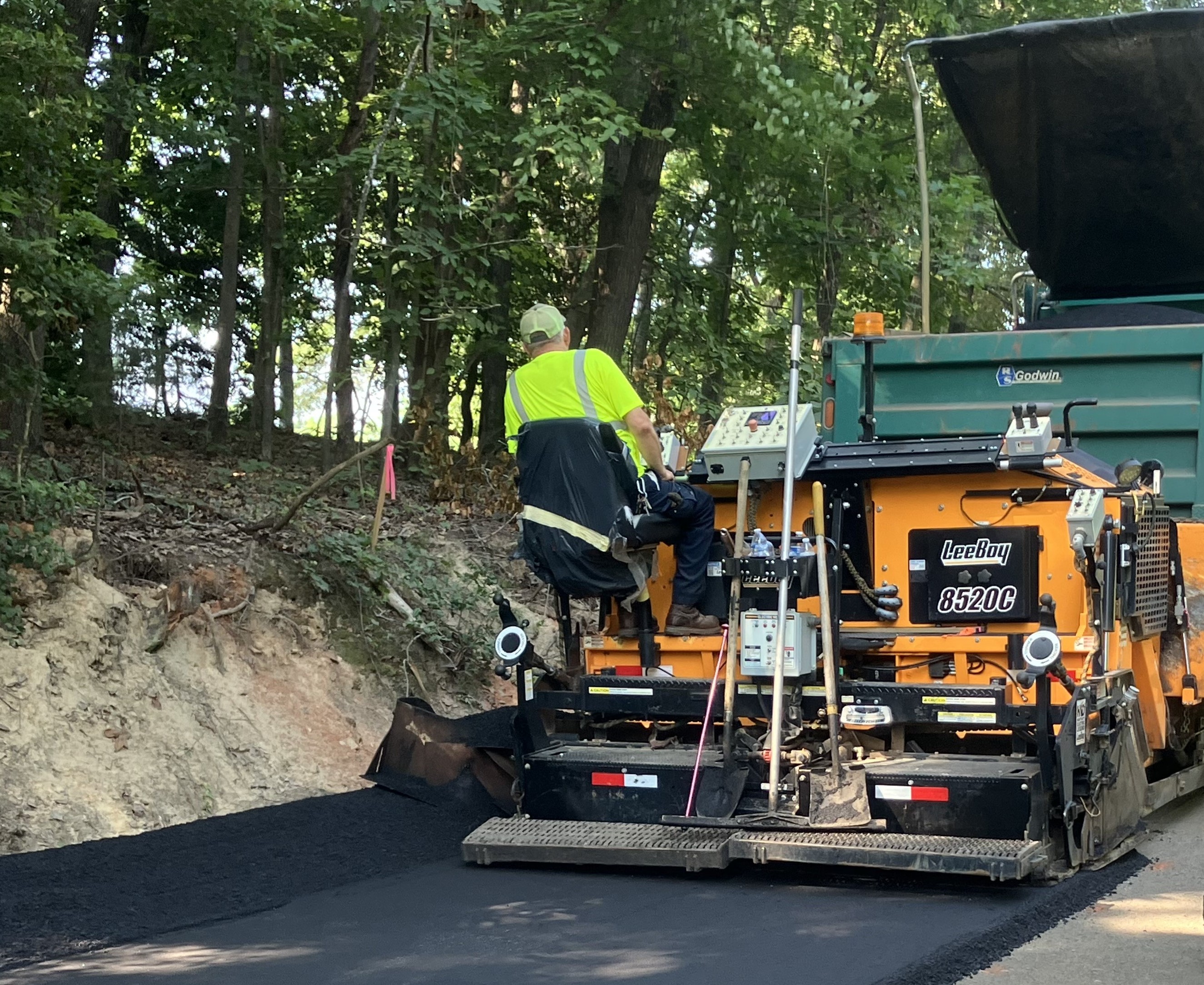 Person using equipment to repave a road surface